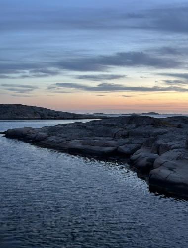 a body of water with rocks in the water at Atelier Blå houses in Rösselvik