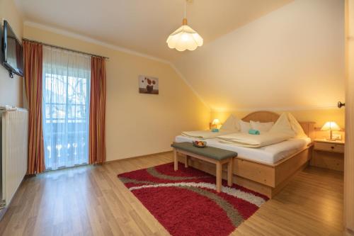 a bedroom with a bed and a red rug at Appartement Jost - Nassfeld in Tröpolach