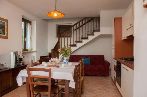 eine Küche und ein Esszimmer mit einem Tisch und einem roten Sofa in der Unterkunft Casale Ulivi in Grutti