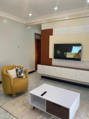 a living room with a couch and a tv at The Vault Heights Apartments in Kampala