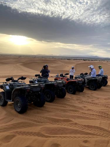 a group of people riding atvs in the desert at Alan Tent Merzouga in Merzouga