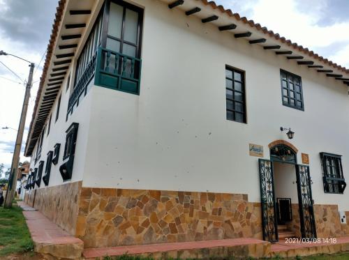 a white building with black windows and a door at Casa Piña in Villa de Leyva