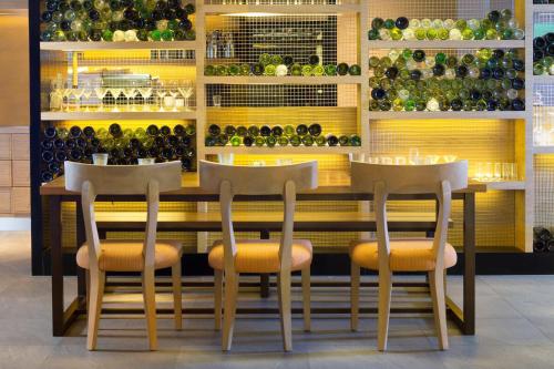 a restaurant with three chairs and a table with wine bottles at The Westin Resort Nusa Dua, Bali in Nusa Dua