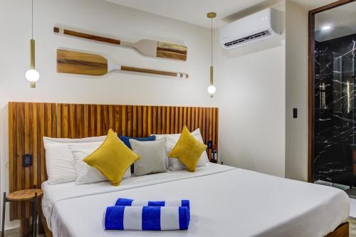 a bedroom with a large bed with yellow and blue pillows at Porto 15 Condominios in Puerto Vallarta
