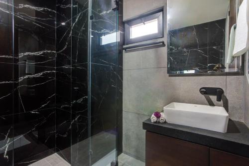a bathroom with a sink and a glass shower at Porto 15 Condominios in Puerto Vallarta