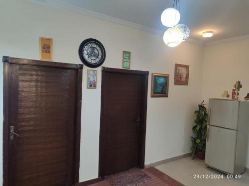 a room with a door and a clock on the wall at Luxury 2BR Family Apt/Wi-Fi / Netflix in Islamabad