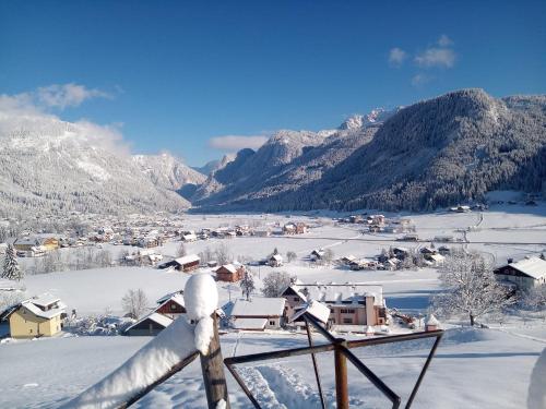 a village covered in snow with mountains in the background at Dangos Mountainview Gosau in Gosau