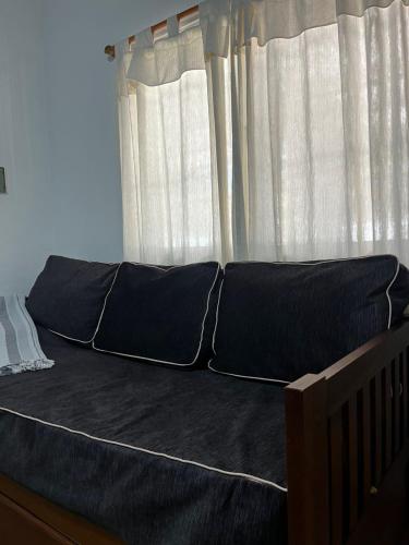 a bed with black sheets in front of a window at Duplex 1 Villa Ramallo in Estación Ramallo