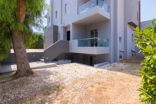 a white building with a tree in front of it at Luxury modern villa with swimming pool, Athens Riviera in Lagonissi