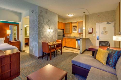 a living room with a couch and a kitchen at Residence Inn by Marriott Ocala in Ocala