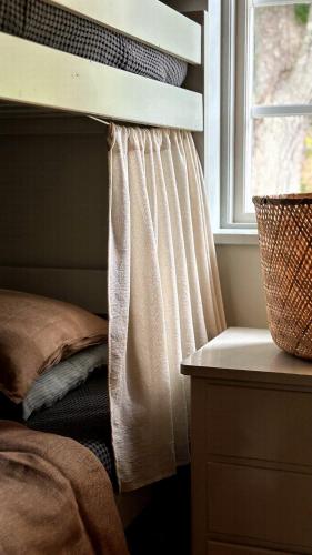 a bedroom with a bed and a window with a curtain at Atelier Blå houses in Rösselvik
