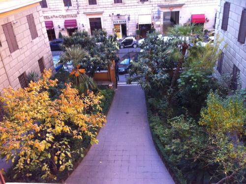 a walkway leading to a garden filled with flowers at Bye Rome Guesthouse in Rome