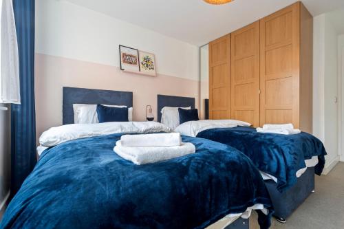 two beds in a room with blue and white sheets at OPK STAYS - Stylish City Centre 1 bed Apartment, Near train station, FREE parking Netflix, SLEEPS 4 in Coventry