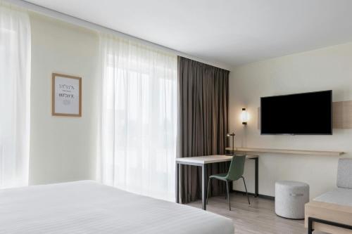 a hotel room with a bed and a desk and a television at Residence Inn by Marriott Hamburg Altona in Hamburg