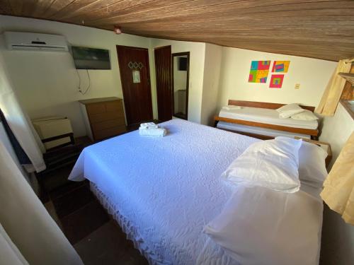 a bedroom with a white bed in a room at Pousada E Restaurante Passart in Morro de São Paulo