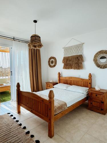 a bedroom with a wooden bed and a window at Nissi Si Lux Boho Apartment on Nissi beach in Ayia Napa