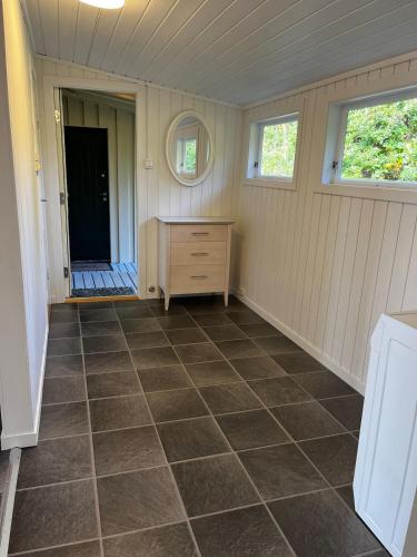 a room with a tiled floor in a house at Delightful vacation home - boat - seaview - garden in Grimstad