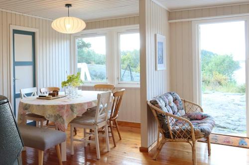 a dining room with a table and chairs at Delightful vacation home - boat - seaview - garden in Grimstad
