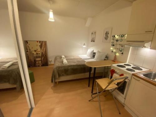 a small room with a bed and a kitchen at Cozy and peaceful Punavuori in Helsinki