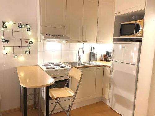 a kitchen with a white refrigerator and a sink at Cozy and peaceful Punavuori in Helsinki