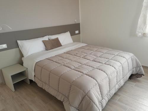 a bedroom with a large bed with a night stand at Alchemilla Bed & Breakfast in Offida