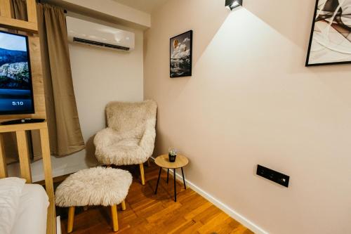 a living room with two chairs and a tv at Bascarsijaapart OWL parking included in Sarajevo