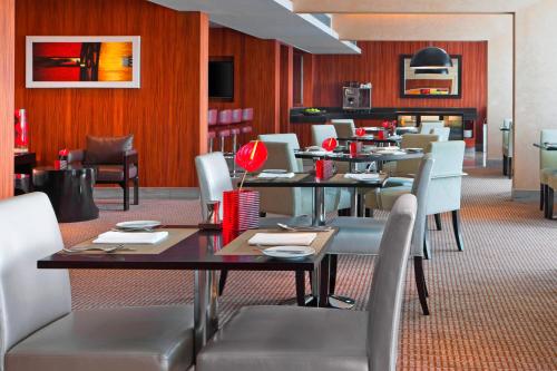 a dining room with tables and chairs in a restaurant at Sheraton Grand Bangalore Hotel at Brigade Gateway in Bengaluru