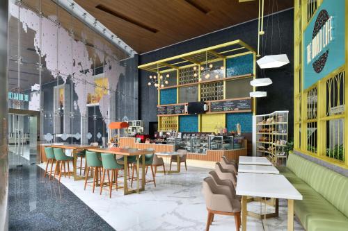 a restaurant with tables and chairs and a bookstore at Sheraton Grand Bangalore Hotel at Brigade Gateway in Bengaluru