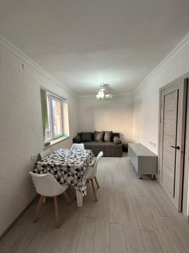a living room with a table and chairs and a couch at Квартира in Gyumri
