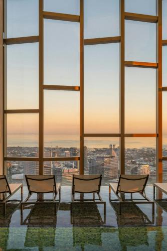 a group of chairs in a room with large windows at The Ritz-Carlton, Melbourne in Melbourne