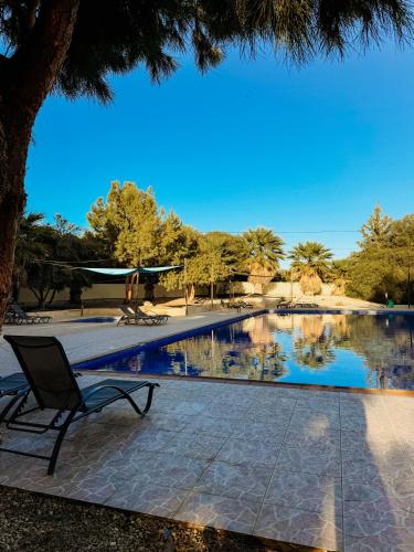 a chair sitting next to a swimming pool at Nissi Si Lux Boho Apartment on Nissi beach in Ayia Napa