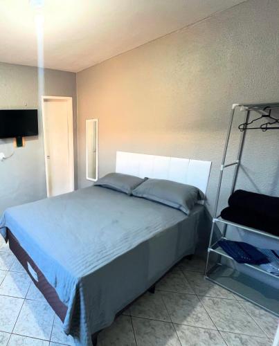 a bedroom with a bed with a blue comforter at Apartamento completo com garagem!Casa Taíba! in Fortaleza