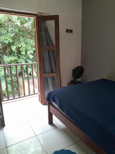 ein Schlafzimmer mit einem Bett und einer Tür zu einem Balkon in der Unterkunft Casa Azul in Paraty