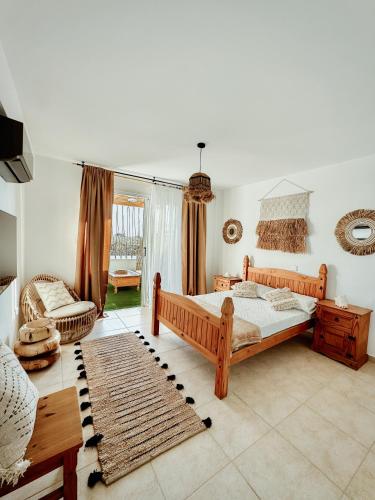 a bedroom with a bed and a couch and a table at Nissi Si Lux Boho Apartment on Nissi beach in Ayia Napa