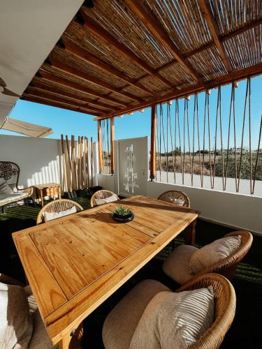 a dining room with a wooden table and chairs at Nissi Si Lux Boho Apartment on Nissi beach in Ayia Napa