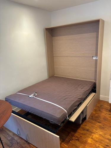 Ce lit se trouve dans une petite chambre dotée de parquet. dans l'établissement Paris Hittorf, à Paris