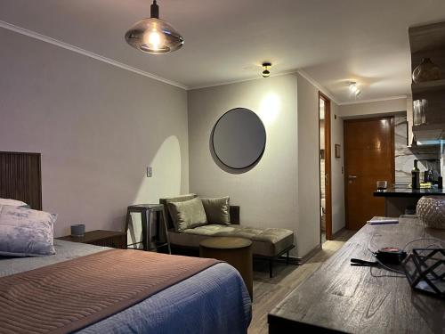 a bedroom with a bed and a couch and a mirror at Roca Town House in Viña del Mar