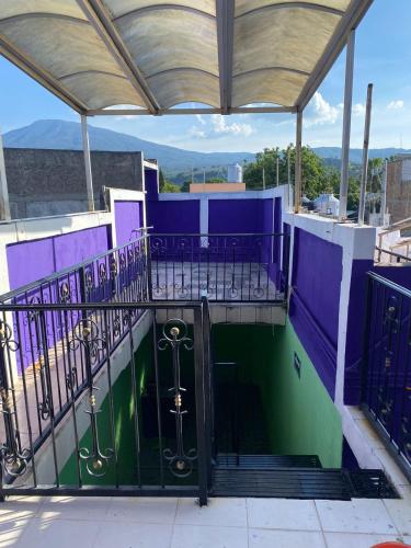 einen Balkon mit einer lila und grünen Tür mit Aussicht in der Unterkunft Hostal tequila in Tequila