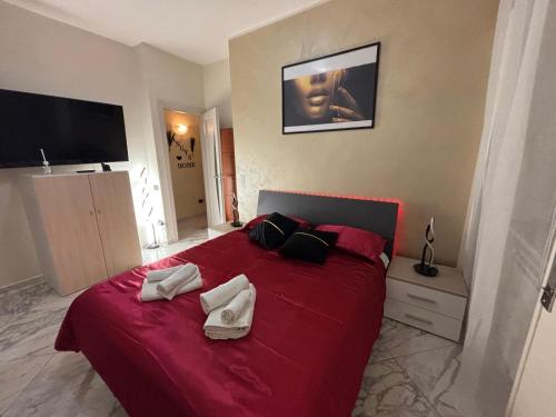 a bedroom with a red bed with two towels on it at Angys Home in Salerno