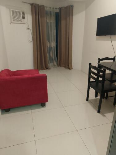 a living room with a red couch and a table at Roxas Blvd Stunning Studio Condo Near US Embassy in Manila