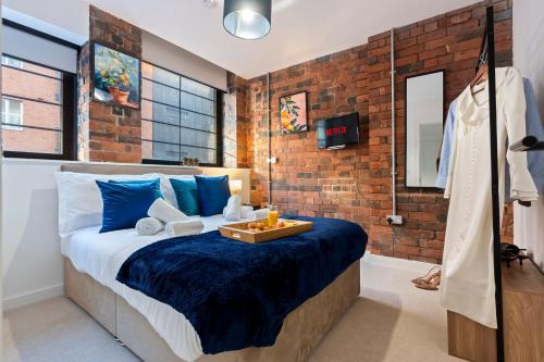 a bedroom with a bed and a brick wall at Signature Suite- City Centre, Pool Table, Canal, Netflix Sleeps 7 in Birmingham