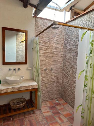 a bathroom with a sink and a shower with a mirror at Casa Cuadros in Curití