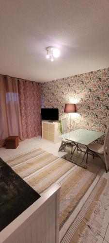 Cette chambre comprend un lit, une table et une télévision. dans l'établissement Le Val Fleuri, à Sète