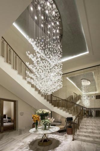 a large chandelier in a lobby with a staircase at The St. Regis Astana in Astana