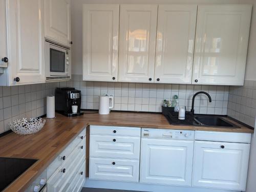 eine Küche mit weißen Schränken und einer Spüle in der Unterkunft *****Saxonia De Luxe***** Neue & Hochwertige 50qm² 2-Zimmer-Ferienwohnung in Chemnitz mit Parkplatz & wie zuhause Wohlfühlatmosphäre - My feel@home Apartment in Chemnitz in Chemnitz