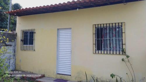 a white house with two windows and a door at Brito Hospedagem in Barreirinhas