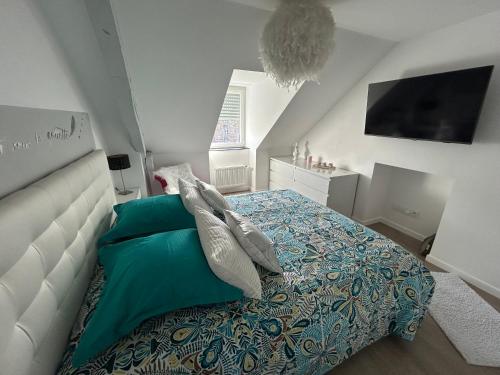 une chambre avec un lit avec des oreillers dessus dans l'établissement Le Cocon Briand, à Fougères