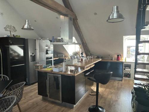 une cuisine avec des appareils en acier inoxydable et un comptoir dans l'établissement Le Cocon Briand, à Fougères