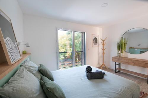 een slaapkamer met een groot bed en een spiegel bij La Villa Nature Canopée du Lac in Seignosse