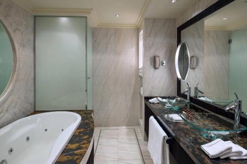 a bathroom with a tub and a large mirror at Sheraton Dammam Hotel & Convention Centre in Dammam